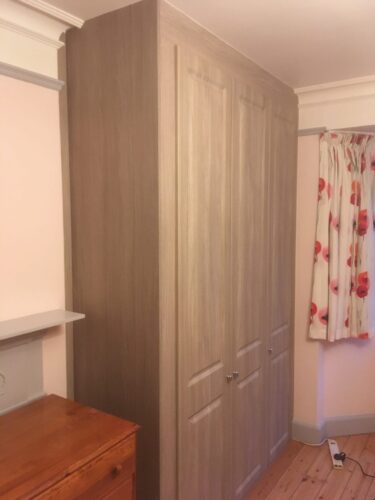 High celling triple wardrobe in Urban Oak with York style hinged doors.