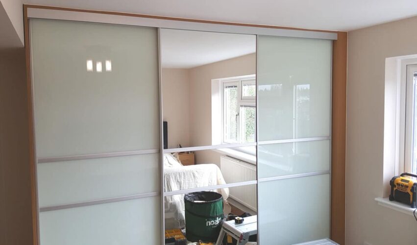 Three Sliding Door Wardrobe with two White glass doors and one Mirror door.