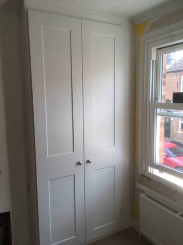 2 Double Wardrobes, one on each side of the chimney breast in Satin White with Shaker style doors. The backs to these wardrobes are available but the customer didn't have the necessary depth so the walls will be painted.