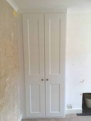 2 Double Wardrobes, one on each side of the chimney breast in Satin White with Shaker style doors. The backs to these wardrobes are available but the customer didn't have the necessary depth so the walls will be painted.