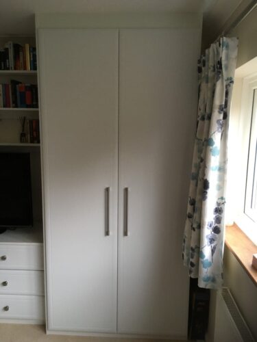 Two double hinged door wardrobes with matching chest of drawers, TV unit and shelves.