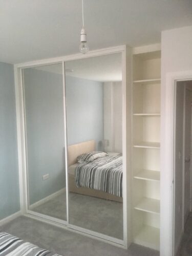 Wardrobe & Shelf Unit. Mirrored doors bespoke double robe in Platinum White with shelf unit in the alcove.