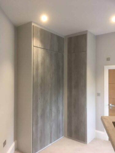 Corner Wardrobe. Wardrobes in 4 bedrooms in Light Grey with doors in London Concrete with Integra style.