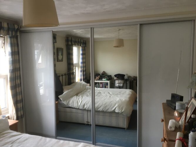 Four Sliding Door Double Wardrobes in Alpine White with 2 Pure White glass & 2 Mirror Aluminium doors.