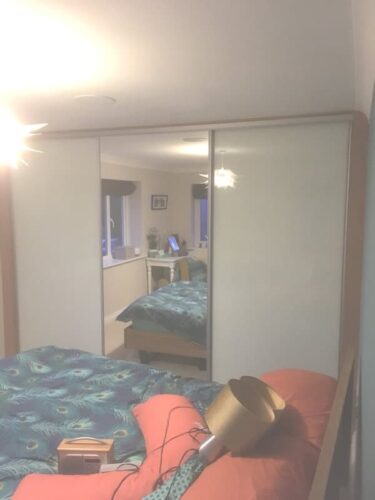 Sliding door wardrobes with mirror centre door.