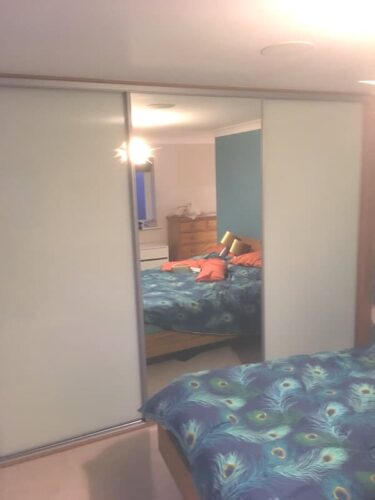 Sliding door wardrobes with mirror centre door.