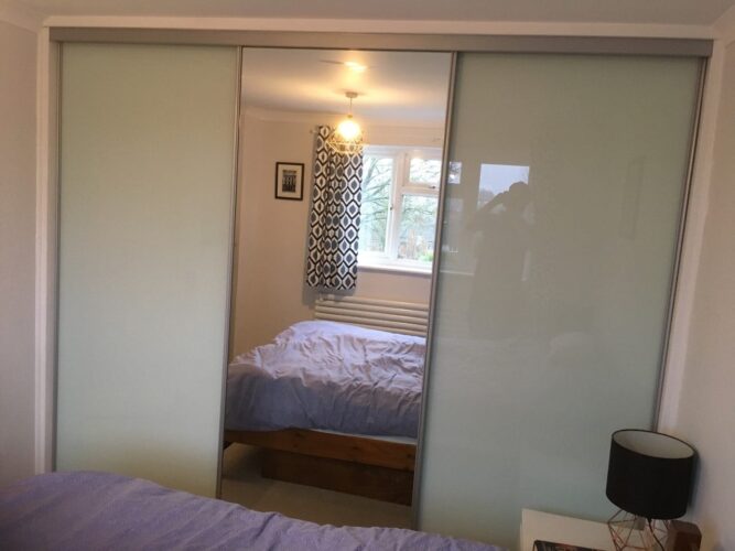 Sliding door wardrobe with mirror centre door.